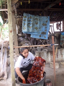 Mufida dyeing a batik with natural dye made from Mahogany bark.